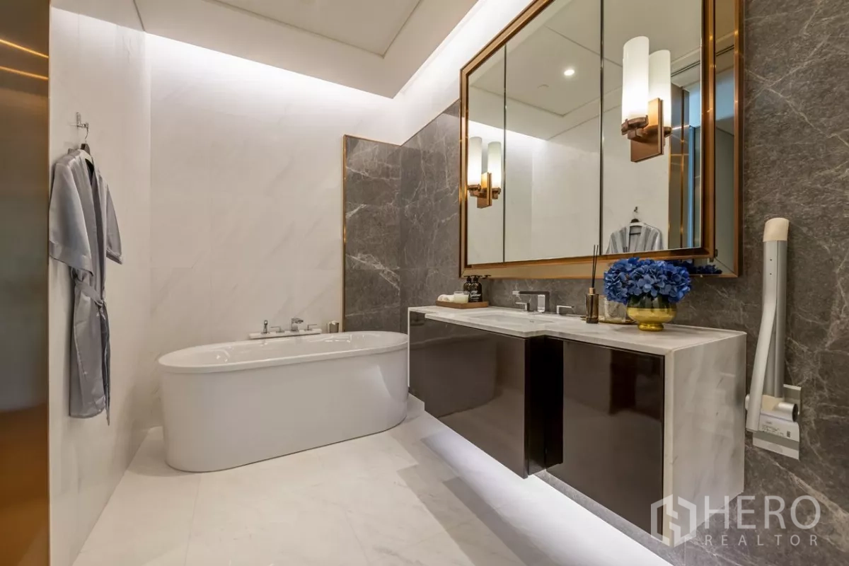Condominium for rent or sale in Pathum Wan, Bangkok - Luxury bathroom with freestanding tub, double vanity and marble walls.