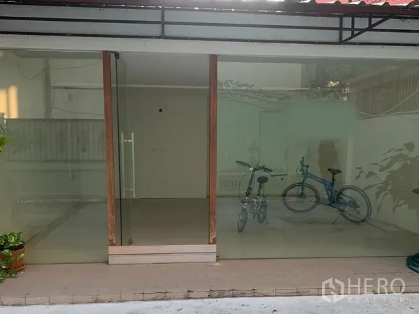 零售空间 出租在Watthana, Bangkok - 临街玻璃门头的小型商铺外观，带铺前瓷砖地面与遮雨棚。