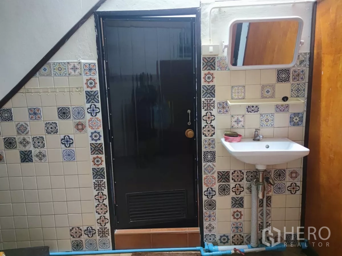 零售空间 出租在Watthana, Bangkok - 花纹瓷砖墙面上的洗手盆与黑色门