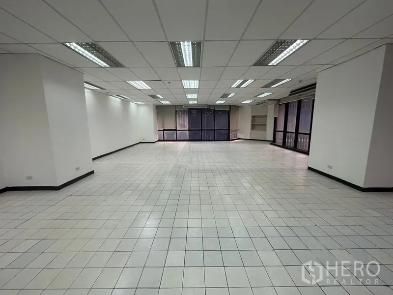 办公空间 出租在Din Daeng, Bangkok - 大型空置办公区，白色瓷砖地面与落地窗。