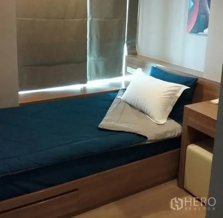 Condominium for rent in Sathon, Bangkok - Second bedroom with single bed, built-in desk and storage, and blackout shades.
