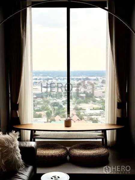 คอนโด ให้เช่า - มุมระเบียงสไตล์เซนพร้อมโต๊ะยาว เบาะสาน และวิวเมืองกว้างของกรุงเทพฯ