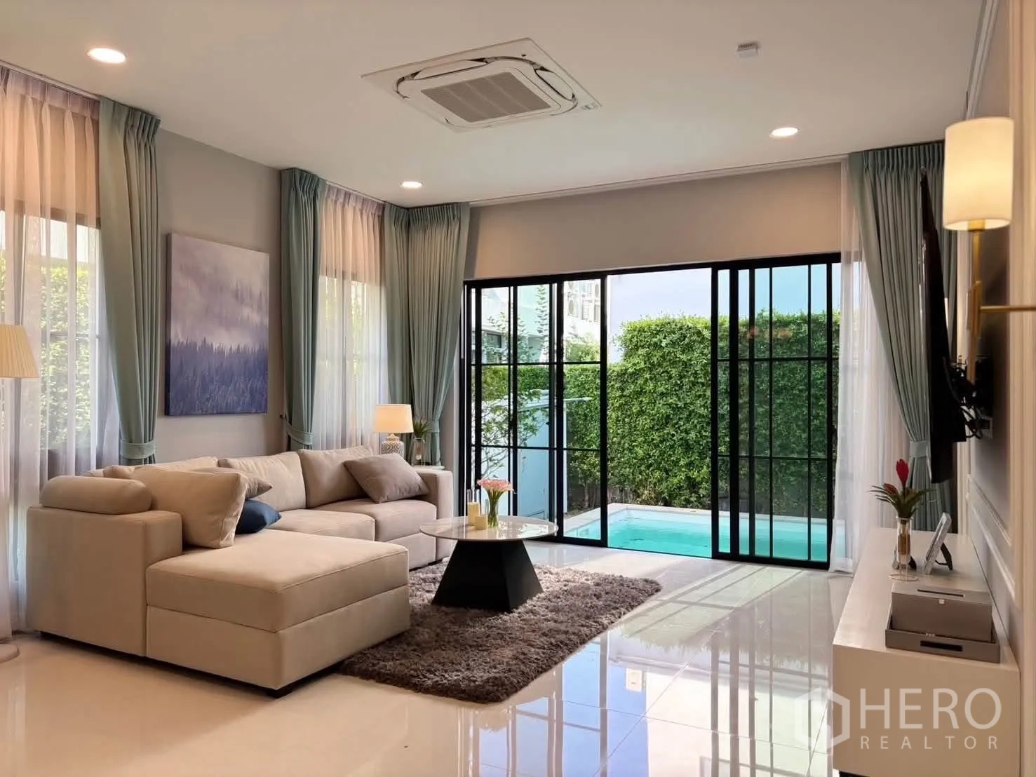 独栋房屋 for rent in Saphan Sung, Bangkok - 采光充足的客厅，L 型沙发，推拉门通向私家泳池。
