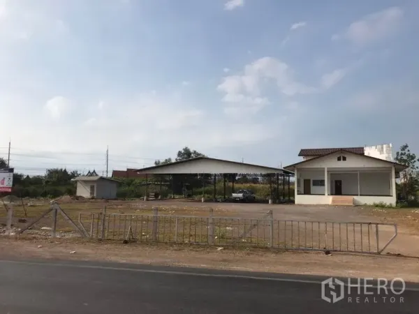 Land for sale in Mueang Samut Sakhon, Samut Sakhon - Wide access from paved road to a large plot featuring a shed, fence and office building.