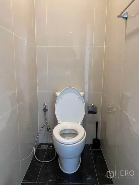 Condominium for rent in Khlong Toei, Bangkok - Separate toilet room with bidet spray in a light-tiled bathroom.