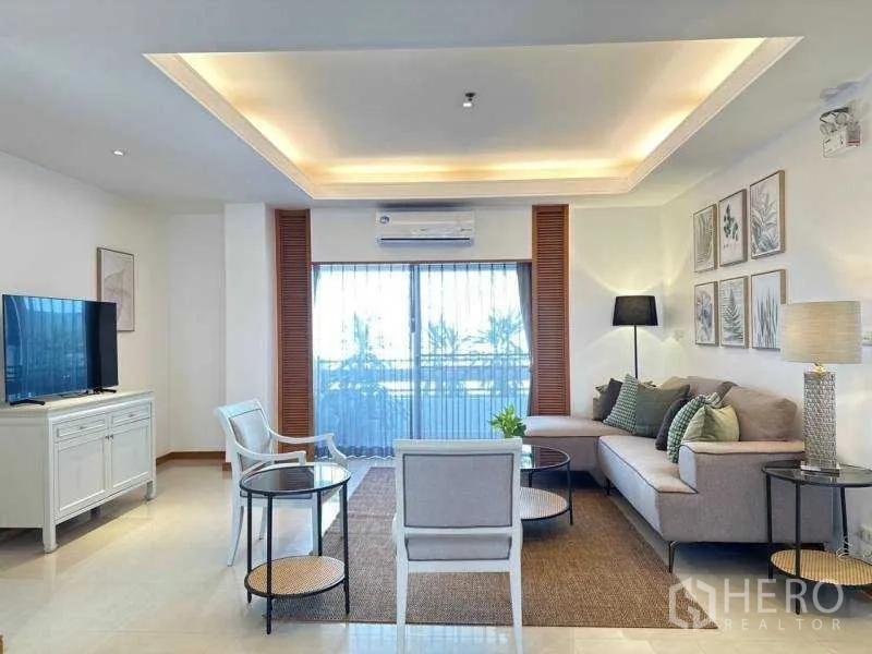 房间 出租 - 客厅朝向大推拉门，吊顶灯光与转角沙发。