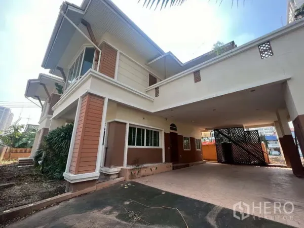 独立式住宅 出租在Watthana, Bangkok - 房屋侧面，带顶停车区与可做花园的地面空间。