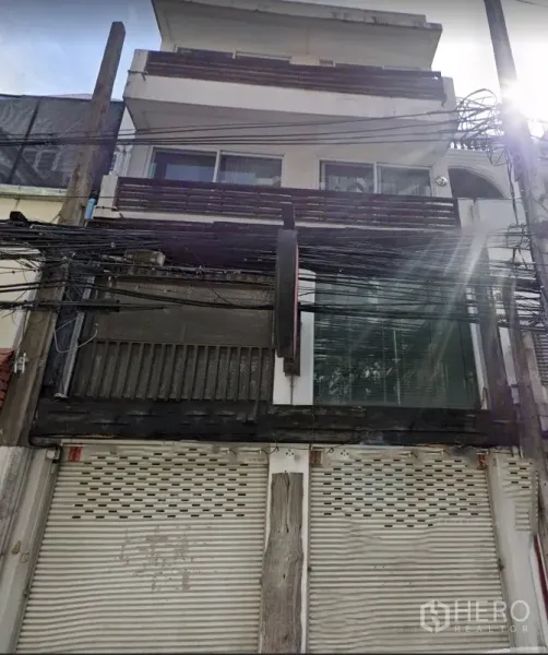 店屋 出租在Watthana, Bangkok - 多层店屋外立面，带阳台和卷帘门。