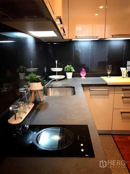 คอนโด ให้เช่าในWatthana, Bangkok - ครัวดีไซน์โมเดิร์น ผนังกระจกสีดำ เตาไฟฟ้า อ่างล้างจาน และไฟใต้ตู้