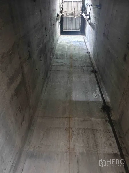 Shophouse for rent in Bang Bo, Samut Prakan - Vertical view of an unfinished cargo lift shaft inside a concrete industrial building.