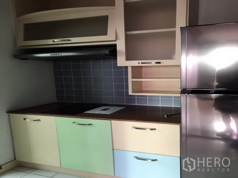 Condominium for rent or sale in Watthana, Bangkok - Kitchen cooktop with hood, tiled backsplash and ample storage.