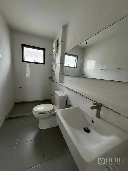 Detached House for rent in Samut Prakan - White-tiled bathroom with long mirror, toilet and shower unit.