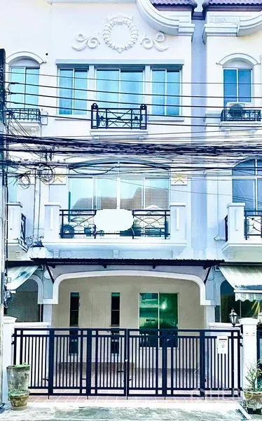 联排别墅 出租在Prawet, Bangkok - 三层白色联排别墅外立面，带大门车位与阳台，位于Srinakarin一带。