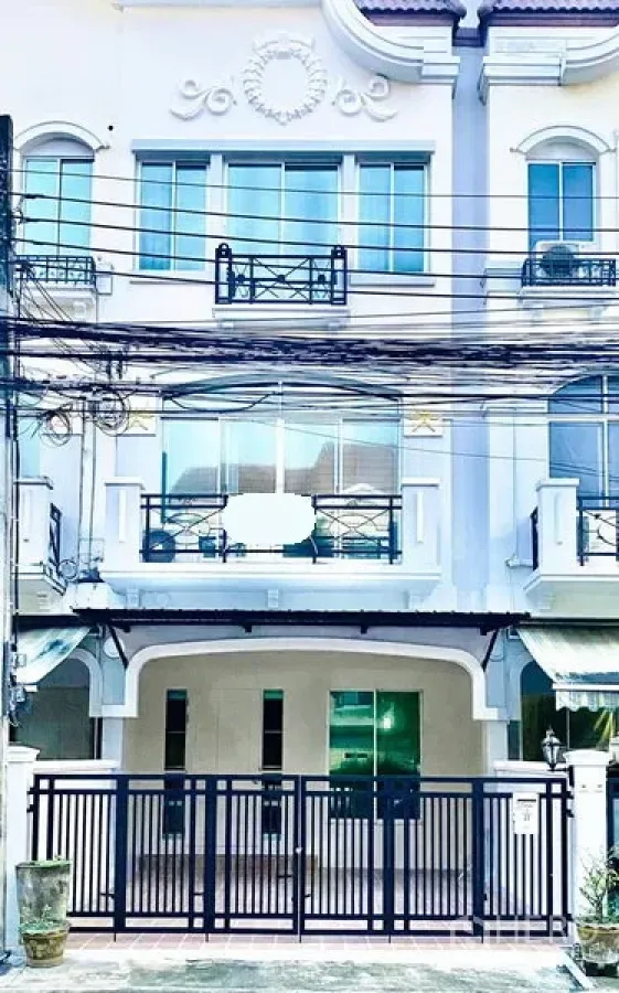 联排别墅 出租在Prawet, Bangkok - 三层白色联排别墅外立面，带大门车位与阳台，位于Srinakarin一带。