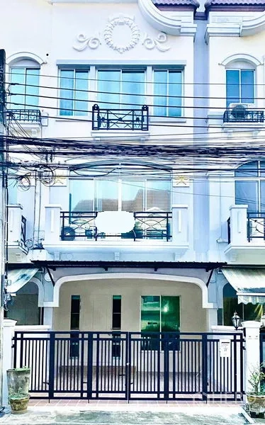 联排别墅 出租在Prawet, Bangkok - 三层白色联排别墅外立面，带大门车位与阳台，位于Srinakarin一带。