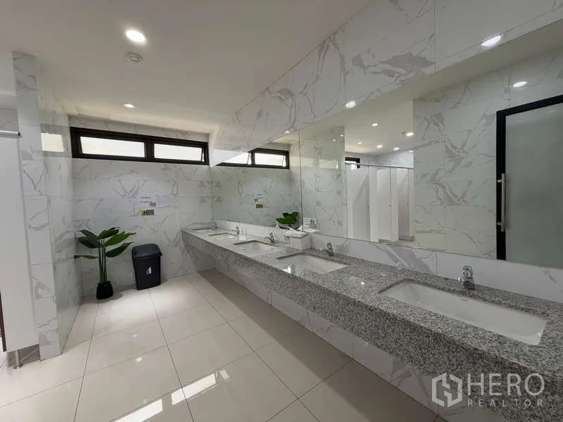 办公空间 出租在Huai Khwang, Bangkok - 干净卫生间，仿大理石瓷砖，长条花岗岩台面与多个洗手池。