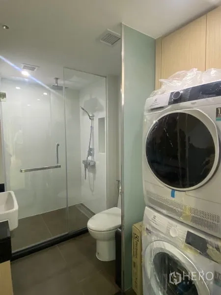 อพาร์ทเมนท์ ให้เช่าในWatthana, Bangkok - ห้องน้ำพร้อมห้องอาบน้ำกระจก โถสุขภัณฑ์ และเครื่องซักผ้า–อบผ้าแบบวางซ้อน