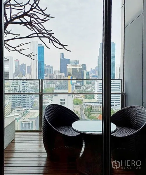 คอนโด ให้เช่าในSathon, Bangkok - ระเบียงมีชุดโต๊ะเก้าอี้หวาย มองเห็นสกายไลน์ย่านสาทร