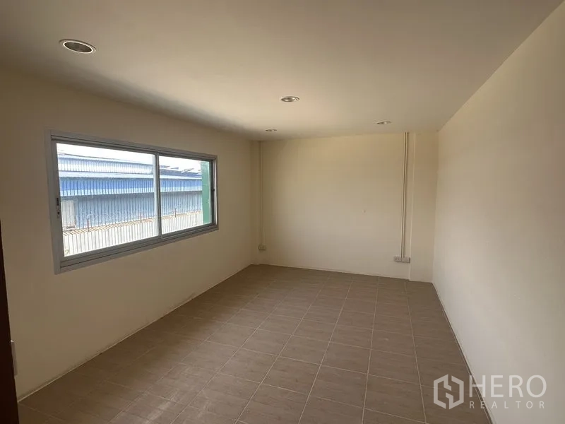 Warehouse for rent in Pathum Thani - Second upper‑floor office or meeting room with window and neutral finishes.
