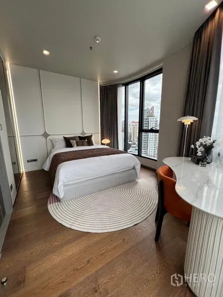 公寓 出租在Ratchathewi, Bangkok - 明亮主卧，拱形床头、圆形地毯与大窗户。