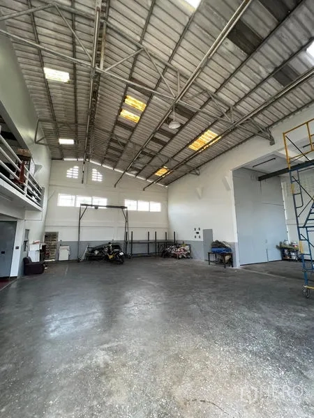 คลังสินค้า ให้เช่าในThung Khru, Bangkok - มุมกว้างของฮอลล์โกดัง พร้อมโครงหลังคาเหล็ก ชั้นลอย และโต๊ะทำงาน