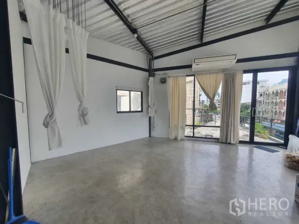 零售空间 出租在Sathon, Bangkok - 角落空间配大面积窗户与阳台入口，城市景观，可见空调与系起的窗帘。