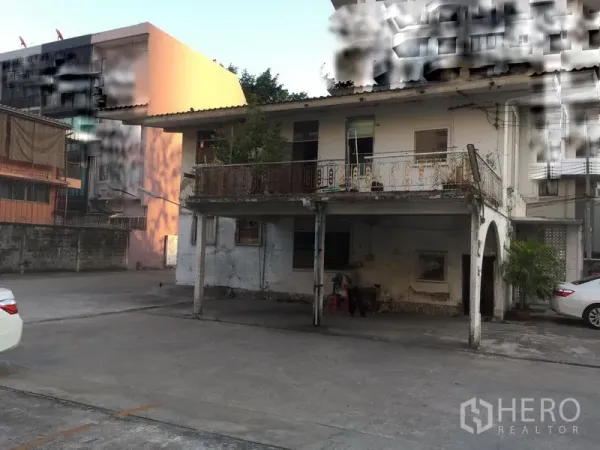 พื้นที่ขายปลีก ให้เช่าในKhlong Toei, Bangkok - มุมมองด้านหน้าบ้านสองชั้นพร้อมระเบียงและที่จอดรถใต้ถุน ติดลานคอนกรีตกว้าง