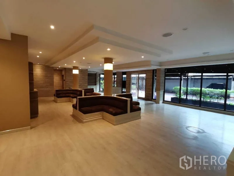 零售空间 出租在Pathum Wan, Bangkok - 临街落地窗接待区，多组卡座并可见室外绿化。