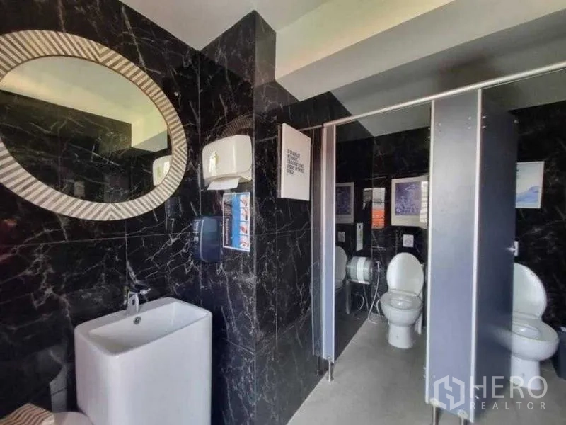 零售空间 出租在Bang Rak, Bangkok - 现代卫生间，黑色大理石墙面，洗手台与独立隔间