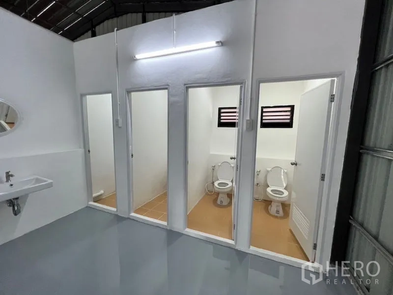 คลังสินค้า ให้เช่าในLat Phrao, Bangkok - ห้องน้ำหลายห้องพร้อมโถสุขภัณฑ์ หน้าต่าง และอ่างล้างมือแบบแขวนผนัง