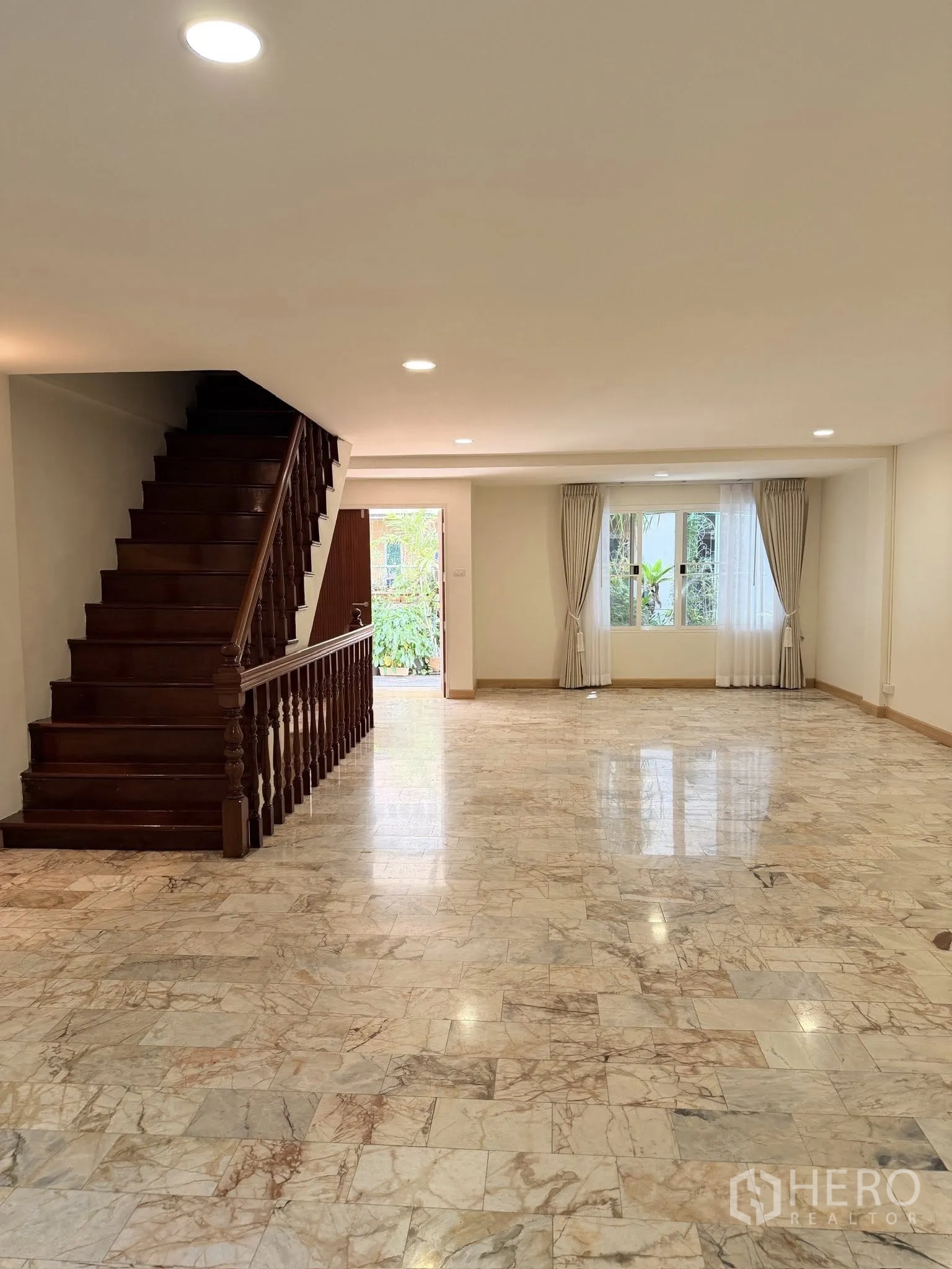 联排别墅 for rent or sale in Yan Nawa, Bangkok - 大开间客厅，木楼梯与大理石地面