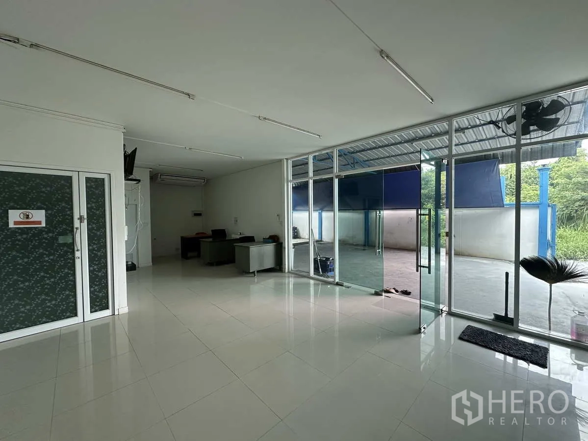 工厂 出租或出售在Bang Yai, Nonthaburi - 前台与办公区，整面落地玻璃面向院内。