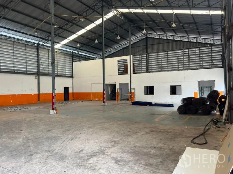 货栈 出租在Prawet, Bangkok - 仓库内部，高挑钢结构屋顶，采光带与通风百叶，混凝土地面及内置办公室
