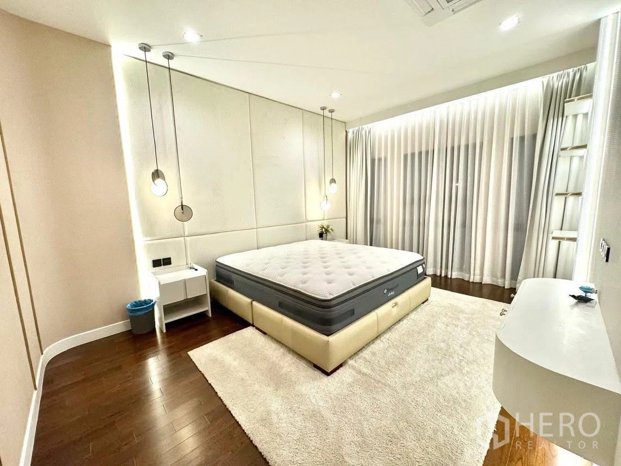 Detached House for sale in Saphan Sung, Bangkok - Light-filled bedroom with full-height curtains, neutral tones and wood floors.