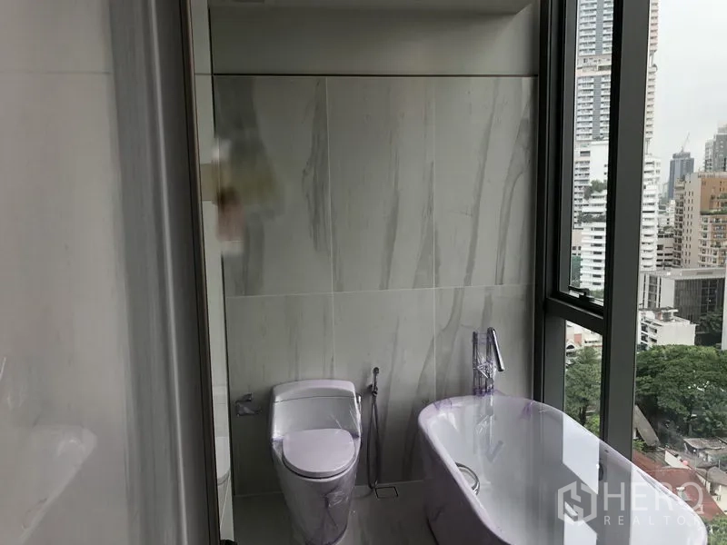 คอนโด ให้เช่าหรือขายในKhlong Toei, Bangkok - ห้องน้ำสไตล์โมเดิร์น มีอ่างอาบน้ำแบบตั้งพื้นและหน้าต่างบานใหญ่เห็นวิวเมือง