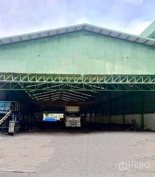 Warehouse for rent in Phra Pradaeng, Samut Prakan - Covered loading zone under a gabled roof with a truck and storage area