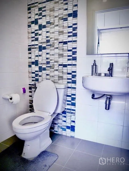 Detached House for rent or sale in Bang Phli, Samut Prakan - Clean bathroom with mosaic tile feature wall, toilet and wall-mounted sink