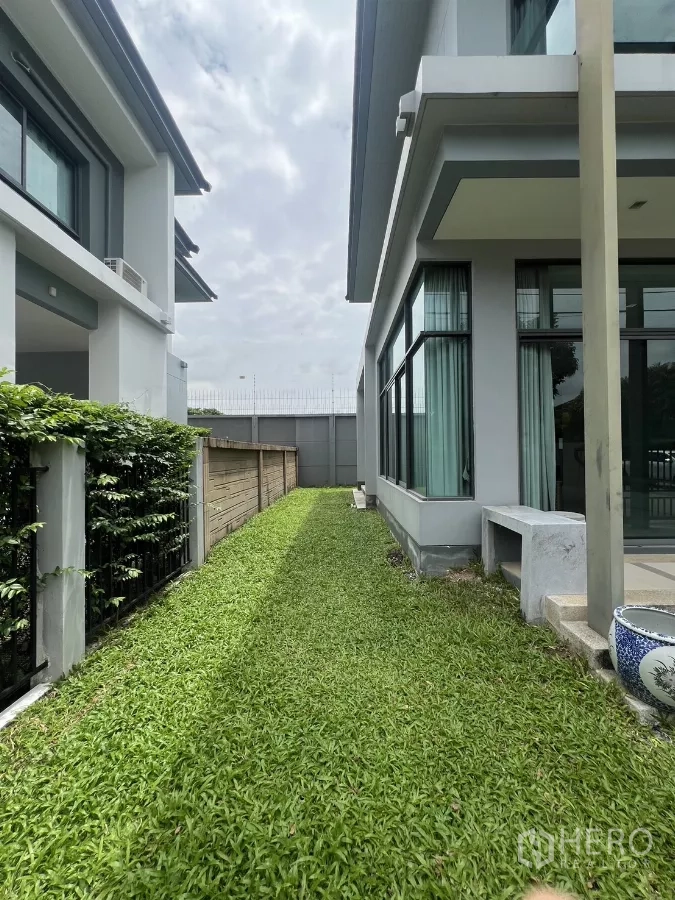 Detached House for rent in Bang Kapi, Bangkok - Long side lawn bordered by hedge and large corner windows.