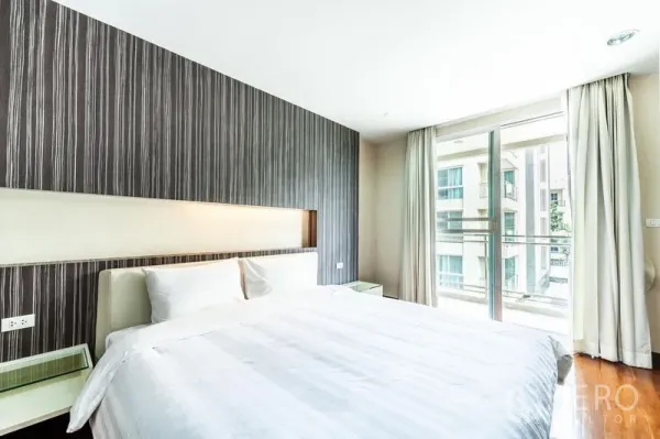 คอนโด ให้เช่าในWatthana, Bangkok - ห้องนอนเตียงคิงพร้อมผนังตกแต่งและประตูกระจกเปิดสู่ระเบียง