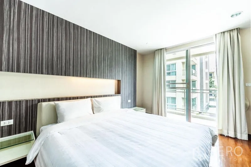 คอนโด ให้เช่าในWatthana, Bangkok - ห้องนอนเตียงคิงพร้อมผนังตกแต่งและประตูกระจกเปิดสู่ระเบียง