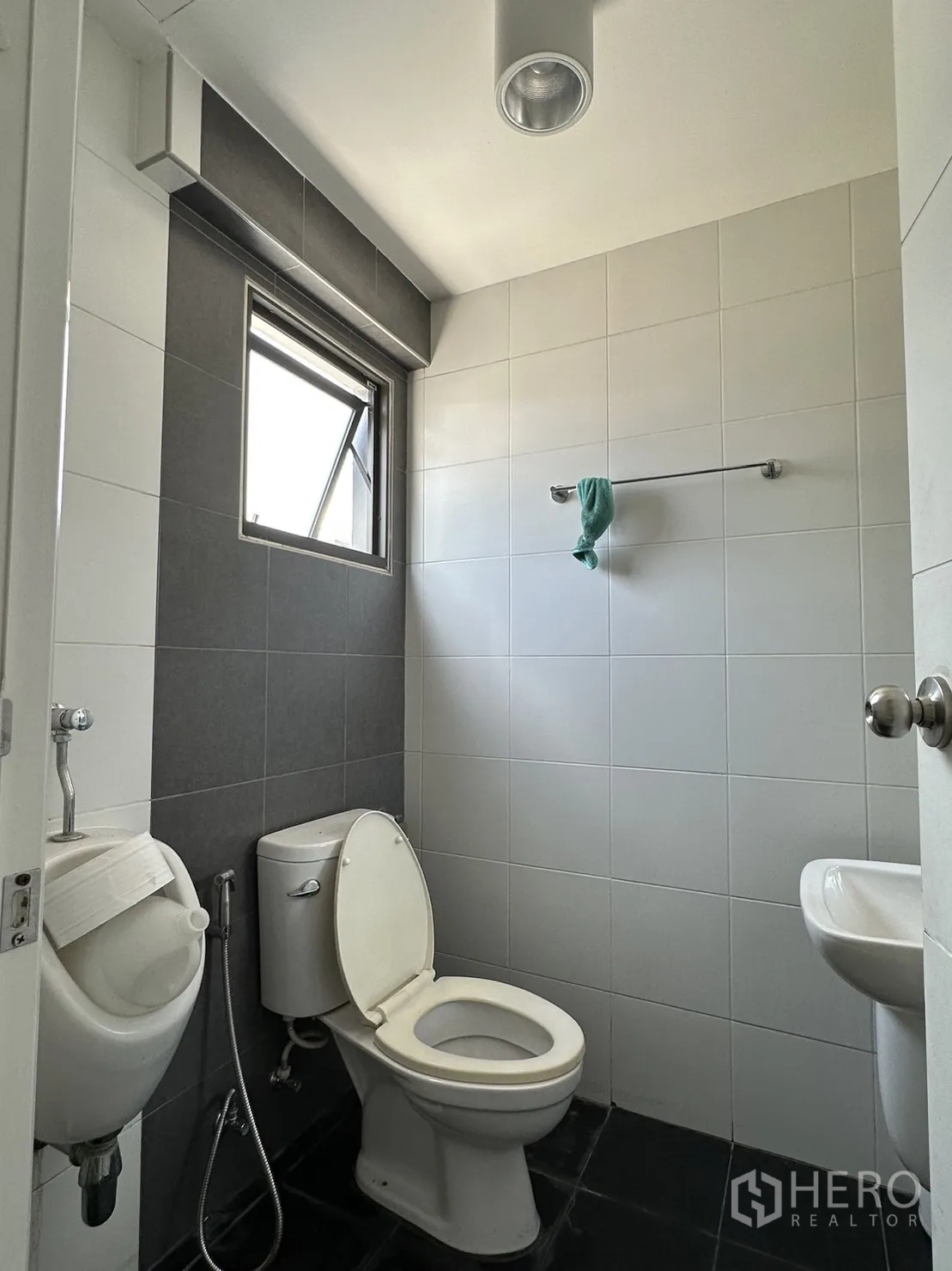 工厂 出租或出售在Pathum Thani - 干净的瓷砖卫生间，含坐便、尿斗和洗手盆。