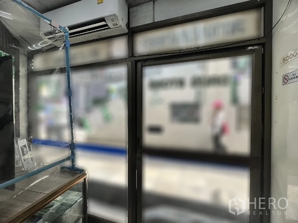 店屋 出售在Watthana, Bangkok - 店内入口视角，黑色边框玻璃门与壁挂空调