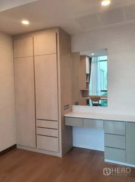 คอนโด ให้เช่าในWatthana, Bangkok - มุมห้องนอนรองพร้อมตู้เสื้อผ้าและโต๊ะเครื่องแป้งติดหน้าต่าง พื้นไม้จริง