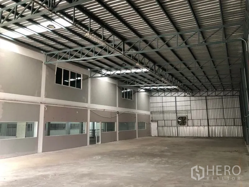 คลังสินค้า ให้เช่าในKhlong Sam Wa, Bangkok - ฮอลล์โกดังเพดานสูง โครงหลังคาเหล็ก พัดลมระบายอากาศ และช่องหน้าต่างยาว