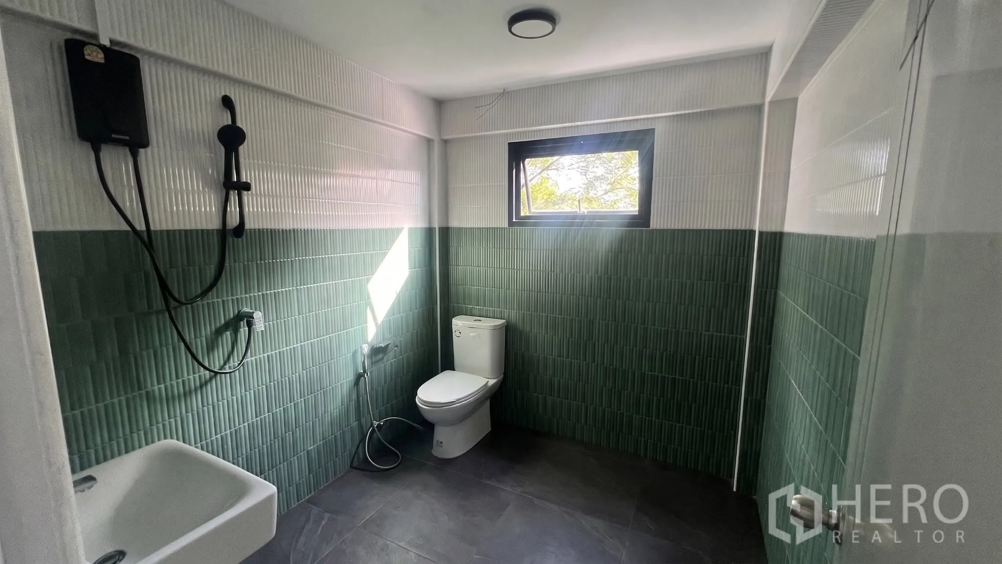 โฮมออฟฟิศ for rent or sale in Phra Khanong, Bangkok - ห้องน้ำกระเบื้องสีเขียวขาวพร้อมหน้าต่างและชุดฝักบัว.