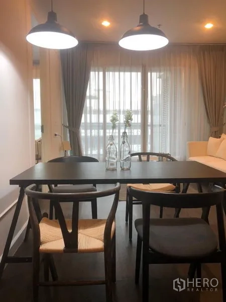 คอนโด ให้เช่าในPathum Wan, Bangkok - มุมทานอาหาร โต๊ะสีดำ เก้าอี้สี่ตัว ใต้โคมไฟแขวนคู่