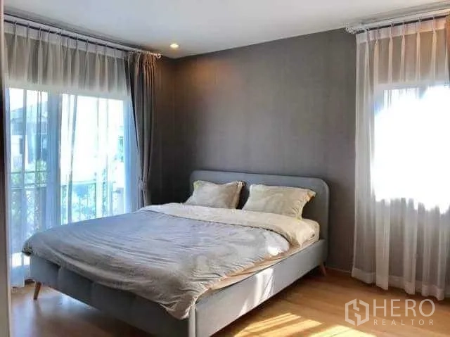 Detached House for rent in Bang Phli, Samut Prakan - Master bedroom with double bed, wood floors and two large windows with sheer curtains.
