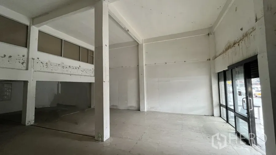 店屋 出租在Watthana, Bangkok - 店屋一层挑高空间，玻璃店面门与瓷砖地面。