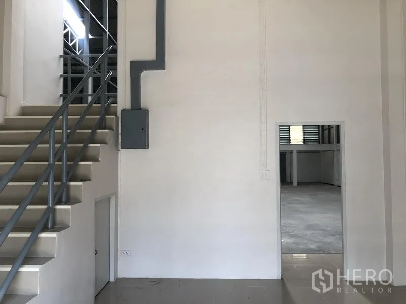 Factory for rent in Pak Kret, Nonthaburi - Close-up of stairwell and electrical panel beside an interior doorway.
