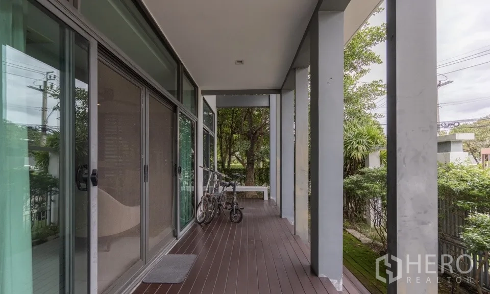 Detached House for rent or sale in Bang Kapi, Bangkok - Shaded front terrace with wooden deck and sliding glass doors.
